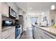Bright kitchen boasts stainless steel appliances, wood flooring, modern cabinets, and a view into the dining area at 5630 W 11Th Pl, Lakewood, CO 80214