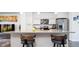 Modern kitchen featuring sleek cabinets, stainless steel appliances, a breakfast bar with seating, and stylish pendant lighting at 5630 W 11Th Pl, Lakewood, CO 80214