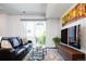 Bright living room featuring a comfortable leather sofa, stylish area rug, and access to a balcony at 5630 W 11Th Pl, Lakewood, CO 80214