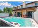 Luxurious backyard featuring a hot tub, outdoor fireplace, and elegant stone accents at 2600 S Adams St, Denver, CO 80210