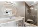 Stylish bathroom features a shower with built-in seating, grey vanity and decorative mirror at 2600 S Adams St, Denver, CO 80210