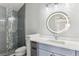 Updated bathroom with a glass-enclosed shower and a round, backlit mirror above the vanity at 2600 S Adams St, Denver, CO 80210