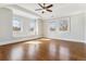 Bright bedroom featuring hardwood floors, a ceiling fan, and sun-filled windows with window seat details at 2600 S Adams St, Denver, CO 80210
