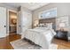 Cozy bedroom featuring hardwood floors, a decorative rug, and an ensuite bathroom at 2600 S Adams St, Denver, CO 80210