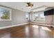 Sunlit bedroom featuring hardwood floors, a ceiling fan, and three windows with window seat details at 2600 S Adams St, Denver, CO 80210