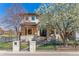 Beautiful two-story home with a well-manicured lawn and a charming stone facade and flowering tree at 2600 S Adams St, Denver, CO 80210