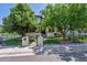 Inviting home with stone accents, mature trees, and a wrought iron fence adding curb appeal at 2600 S Adams St, Denver, CO 80210