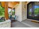 Inviting front porch with stone facade, rocking chairs, and an ornate front door at 2600 S Adams St, Denver, CO 80210