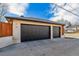 A two car garage with black doors and exterior lighting on a bright, sunny day at 2600 S Adams St, Denver, CO 80210