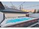 Luxurious hot tub with vibrant blue water, surrounded by a wooden deck and illuminated by string lights at sunset at 2600 S Adams St, Denver, CO 80210