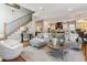 Open-concept living room features a staircase, modern furnishings, and seamless flow into the kitchen at 2600 S Adams St, Denver, CO 80210