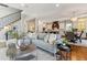 Open-concept living room featuring a staircase, kitchen view, and stylish decor at 2600 S Adams St, Denver, CO 80210