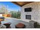 Cozy patio with a stone fireplace, TV, outdoor seating, and a view of the manicured backyard at 2600 S Adams St, Denver, CO 80210