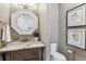 Stylish powder room featuring a marble countertop, octagonal mirror and artwork at 2600 S Adams St, Denver, CO 80210