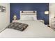 Comfortable bedroom featuring a large bed, a blue accent wall, and stylish lamps and nightstands at 2 N Adams St # 108, Denver, CO 80206