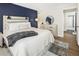 Bright bedroom with a blue accent wall, wood-look flooring, and a view of the en suite bathroom at 2 N Adams St # 108, Denver, CO 80206