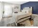 Cozy bedroom with blue accent wall, white bedding, and ample natural light from the window at 2 N Adams St # 108, Denver, CO 80206