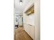 Hallway with wood floors, white accent walls, and a built-in cabinet with white hexagon tiling at 2 N Adams St # 108, Denver, CO 80206