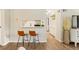 Bright kitchen features a breakfast bar with two chairs, light-colored cabinets, and wood flooring at 2 N Adams St # 108, Denver, CO 80206
