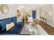 Stylish living room featuring a blue sectional sofa, dining area, and hardwood floors at 2 N Adams St # 108, Denver, CO 80206
