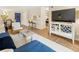 Comfortable living room featuring a modern entertainment center, dining area, and hardwood floors at 2 N Adams St # 108, Denver, CO 80206