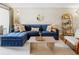 Inviting living room with a blue sectional sofa, bright natural light, and a decorative wall mirror at 2 N Adams St # 108, Denver, CO 80206