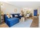 Bright living room features hardwood floors, blue sectional, and adjacent dining area at 2 N Adams St # 108, Denver, CO 80206