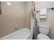 Bathroom featuring a tub, shower, tile surround, and toilet at 8378 S Upham Way # B305, Littleton, CO 80128