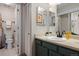 Well lit bathroom featuring a modern vanity and fixtures, toilet, and closet with folding doors at 8378 S Upham Way # B305, Littleton, CO 80128