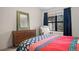 Bright bedroom featuring a colorful quilt, dark wood dresser and a window with natural light at 8378 S Upham Way # B305, Littleton, CO 80128