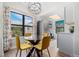 Bright dining area features a round glass table with yellow chairs and a modern chandelier at 8378 S Upham Way # B305, Littleton, CO 80128