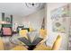 Open concept dining area with glass table, seating for four, and views into the living room with fireplace at 8378 S Upham Way # B305, Littleton, CO 80128