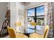 Bright dining area features a round glass table with yellow chairs and bright natural light at 8378 S Upham Way # B305, Littleton, CO 80128