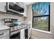 Kitchen features stainless steel range, built in microwave, and bright window at 8378 S Upham Way # B305, Littleton, CO 80128