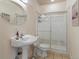 Bathroom featuring a pedestal sink, toilet, and glass-enclosed shower with tile surround at 7858 Oban Ct, Lone Tree, CO 80124