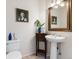 Charming powder room featuring a pedestal sink, decorative mirror, and artistic wall decor at 7858 Oban Ct, Lone Tree, CO 80124