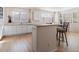 Well-lit kitchen with white cabinetry, hardwood floors, and a breakfast bar with seating at 7858 Oban Ct, Lone Tree, CO 80124
