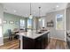 Modern kitchen island view with stainless appliances, dining area, and bar for seating at 5351 Warrior St, Frederick, CO 80504