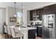 Modern kitchen with stainless steel appliances, dark cabinetry, and white countertops at 5351 Warrior St, Frederick, CO 80504