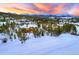 Serene aerial view of a snow-covered property offering a peaceful escape surrounded by mountains and tall pine trees at 219 Glen Eagle Loop, Breckenridge, CO 80424
