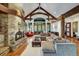 Inviting living area with a stone fireplace, wooden beams, and expansive windows offering scenic outdoor views at 219 Glen Eagle Loop, Breckenridge, CO 80424