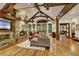 Spacious living room with a stone fireplace, wood floors, exposed beams, and large windows at 219 Glen Eagle Loop, Breckenridge, CO 80424