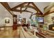 Expansive living room features a stone fireplace, wooden beams, and an open layout connecting to the kitchen at 219 Glen Eagle Loop, Breckenridge, CO 80424