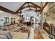 Spacious living room with a stone fireplace, wooden beams, and an open floor plan seamlessly connecting living spaces at 219 Glen Eagle Loop, Breckenridge, CO 80424