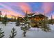 Exterior showing a back deck and numerous windows overlooking the wintery landscape at 219 Glen Eagle Loop, Breckenridge, CO 80424