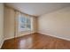 Sunny bedroom featuring hardwood floors and bright window with lush outside view at 6317 Ruby Hill Dr, Erie, CO 80516