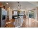 Open kitchen with wood cabinets, stainless steel appliances, island, and sliding glass doors at 6317 Ruby Hill Dr, Erie, CO 80516