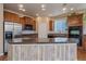 Spacious kitchen featuring a center island with seating, granite countertops, and wood cabinetry at 6317 Ruby Hill Dr, Erie, CO 80516