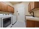 Well-equipped laundry room boasts modern washer/dryer, cabinetry, sink, and stylish patterned flooring at 6317 Ruby Hill Dr, Erie, CO 80516