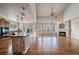 Spacious living room with hardwood floors, fireplace, and a kitchen island visible in the background at 6317 Ruby Hill Dr, Erie, CO 80516